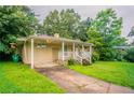 Quaint home with attached carport and cozy front porch, set on a lush green lawn at 3409 Hyland Dr, Decatur, GA 30032
