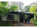 Shot of a derelict home's overgrown yard and exterior in visible disrepair at 2440 Andy Mountain Rd, Villa Rica, GA 30180
