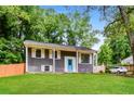Attractive home with a well-maintained lawn, gray siding, and a vibrant blue front door at , Forest Park, GA 30297