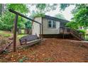 View of the home's backyard with a wooden swing and stairs leading up to the house at 407 Doris Dr, Woodstock, GA 30188