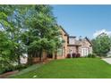 Two-story brick home with stone accents, manicured lawn, and mature shade tree at 3410 Enclave Mill Ct, Dacula, GA 30019