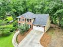 Birds-eye view of a well-maintained home with a spacious driveway and lush greenery at 135 Crimson Rdg, Tyrone, GA 30290