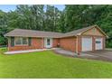 A well-maintained brick home with a two-car garage and lush green lawn offers suburban charm at 1738 Sherry Ln, Jonesboro, GA 30236