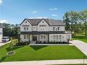 Wide-angle aerial view of landscaped lawn, long driveway, 2-car garage and black trimmed windows at 7420 Wild Violet Dr, Cumming, GA 30040