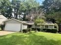 Charming single-story home with a well-manicured front lawn and mature trees at 10630 Worthington Hills Mnr, Roswell, GA 30076