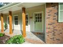 Charming front porch with wooden pillars and a green front door at 5254 Corinth Dr, Stone Mountain, GA 30087