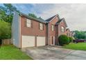Charming two-story brick home with two-car garage and well-manicured lawn at 6528 Carriage Ln, Stone Mountain, GA 30087