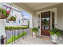 Covered porch showcasing brick flooring, iron railings, and decorative hanging plants at 205 Maplewood Dr, Roswell, GA 30075