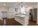 Stylish kitchen with white cabinets, stainless steel appliances, a center island and modern lighting at 3480 Tanbark Ne Ct, Brookhaven, GA 30319