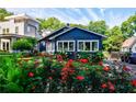 Charming blue home with vibrant red rose bushes, lush green lawn, and inviting curb appeal at 1190 Francis Nw St, Atlanta, GA 30318