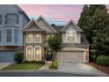Charming brick home featuring a two-car garage, manicured lawn, and beautiful landscaping during sunset at 200 Mystic Ct, Atlanta, GA 30342