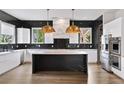 Modern kitchen featuring stainless steel appliances, black backsplash, white cabinets, and marble island at 2220 Meadowvale Ne Dr, Atlanta, GA 30345