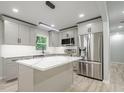 Modern kitchen featuring stainless steel appliances, gray cabinets and a center island at 3160 Ann Se Rd, Smyrna, GA 30080
