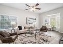 Bright and airy living room with large windows, neutral decor, ceiling fan, and stylish furnishings at 3440 Oaktree Way, Stonecrest, GA 30038
