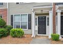 Charming townhouse entrance with a black front door and well-maintained landscaping at 2084 Del Lago Nw Cir # 1, Kennesaw, GA 30152