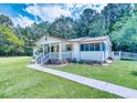 Charming single-story home with a well-maintained lawn, inviting front porch, and beautiful surrounding trees at 5160 W Chapel Hill Rd, Douglasville, GA 30135
