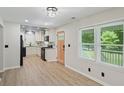 Bright kitchen with white cabinets, granite countertops, black appliances, and stylish luxury vinyl plank flooring at 5160 W Chapel Hill Rd, Douglasville, GA 30135
