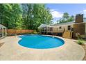 Backyard featuring a large in-ground swimming pool, complemented by a spacious deck and surrounding greenery at 1035 Hunterhill Dr, Roswell, GA 30075