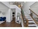Bright foyer features hardwood floors, staircase with wooden railing, and an open view into the living room at 2167 Merrymount Dr, Suwanee, GA 30024