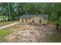 Lovely single-story brick home nestled among mature trees and a front yard at 6010 Fieldcrest Dr, Morrow, GA 30260