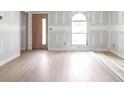Spacious living room with new wood flooring and an arched window at 6010 Fieldcrest Dr, Morrow, GA 30260