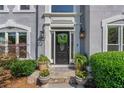 Inviting entryway with decorative wreath, potted plants, and stone walkway at 681 Braidwood Nw Ter, Acworth, GA 30101