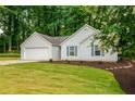 Well-kept one-story home featuring a green lawn, garage, and fresh landscaping at 2109 Tranquility Ct, Woodstock, GA 30188