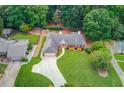 Aerial view of a well-maintained home with lush landscaping, long driveway, and backyard wooded area at 3550 Miller Farms Ln, Peachtree Corners, GA 30096