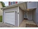 Close-up of a townhome entrance with a garage and a gray front door under a porch at 6927 Gallant Se Cir # 11, Mableton, GA 30126