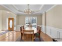 Bright dining room showcasing classic wainscoting, elegant chandelier, and hardwood floors adjacent to the entry at 1107 Carroll Ct, Norcross, GA 30071