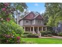 Charming two-story home with a covered front porch surrounded by lush landscaping at 47 Oakridge Se Ave, Atlanta, GA 30317