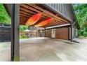Spacious carport with kayaks above, leading to an outdoor patio area and fenced yard at 1050 Lake Charles Dr, Roswell, GA 30075