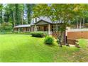 Charming brick home with mature trees, manicured lawn and side entrance, highlighting outdoor space at 1050 Lake Charles Dr, Roswell, GA 30075