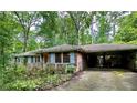 Charming single story brick house with carport and front porch nestled among mature trees at 1333 Council Bluff Ne Dr, Atlanta, GA 30345