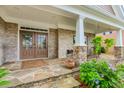 A cozy front porch featuring stone supports and brickwork, with ample space for seating at 2727 Bearcreek Pl, Buford, GA 30519