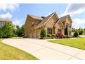 Beautiful brick home featuring attached three car garage, manicured lawn and lovely landscaping at 6110 Read Rd, Suwanee, GA 30024