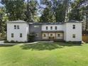 Inviting two-story home featuring a modern gray and white exterior, a manicured lawn, and mature trees at 3899 Carlton Dr, Chamblee, GA 30341