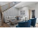 Cozy living room with a plush sofa, stylish blue accent chairs, and a staircase with black iron railings at 3899 Carlton Dr, Chamblee, GA 30341