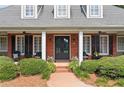 Inviting front porch features brick accents, white columns, and cozy seating, creating a welcoming entrance at 501 Avery Creek Pointe, Woodstock, GA 30188