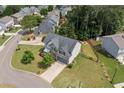 Aerial view of the charming two-story home with a well-maintained lawn, mature trees, and a fenced backyard at 115 Greenbrier Way, Canton, GA 30114