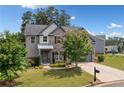 Inviting two-story home with stone accents, gray siding, mature landscaping, and a two-car garage at 115 Greenbrier Way, Canton, GA 30114