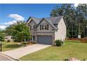 Beautiful two-story home featuring a stone facade, neutral siding, mature landscaping, and a two-car garage at 115 Greenbrier Way, Canton, GA 30114