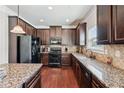 Well-equipped kitchen with stainless steel appliances, granite countertops and dark wood cabinetry at 3024 Bridgehaven Ct, Snellville, GA 30039