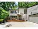 Modern two-story house with a large driveway, wooden deck and tasteful exterior details at 4290 Inverness Ne Ct, Roswell, GA 30075