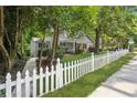View of a home with a white picket fence, lush landscaping, and a sidewalk leading to the entrance at 22 Peachtree Hills Ne Ave, Atlanta, GA 30305