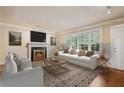 Inviting living room featuring a cozy fireplace, large windows, and neutral decor at 22 Peachtree Hills Ne Ave, Atlanta, GA 30305
