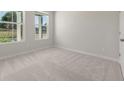 Neutral bedroom featuring plush carpet, two windows, and a closet at 2625 Mourning Dove Dr (Lot 47), Grayson, GA 30017