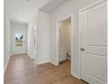 Bright hallway with wood-look floors, white walls, and doors leading to other rooms at 2625 Mourning Dove Dr (Lot 47), Grayson, GA 30017