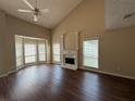 Bright living room featuring a fireplace, large windows, high ceilings, and wood flooring at 312 Yarbrough Ct, Dacula, GA 30019