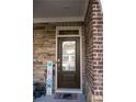 Stylish front door with glass inset and a 'Welcome' sign, set against a stone and brick facade at 513 Forest Ln, Canton, GA 30114